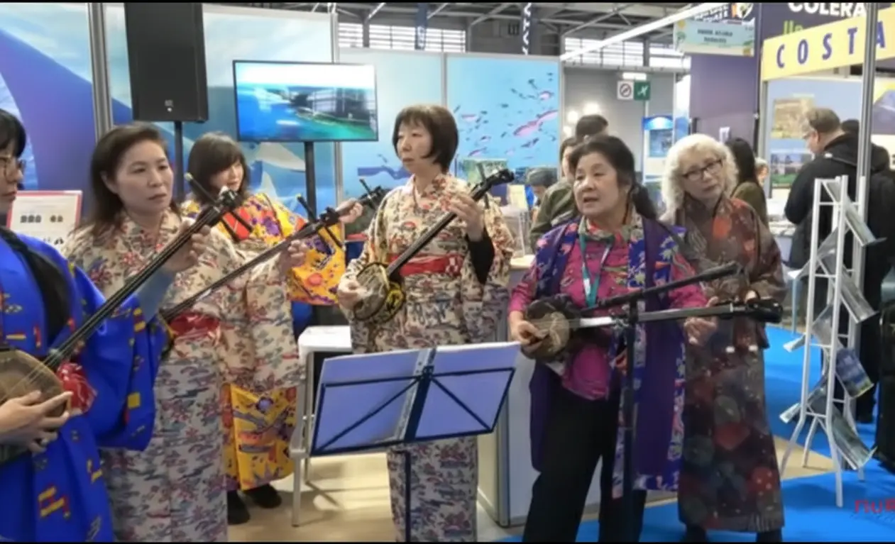 Groupe de musiciennes en kimono jouant du sanshin au Salon de la Plongée à Paris, sur le stand d’Okinawa.